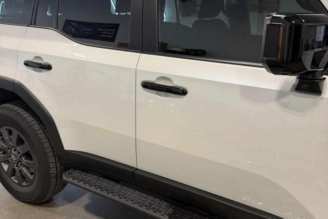 Black step bars and door handles on a white Toyota Land Cruiser inside the studio