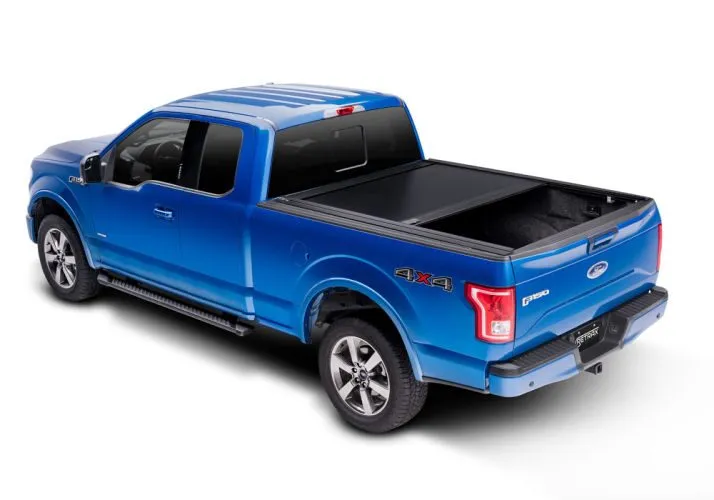 A hard tri-fold tonneau cover folded once open on a silver pickup