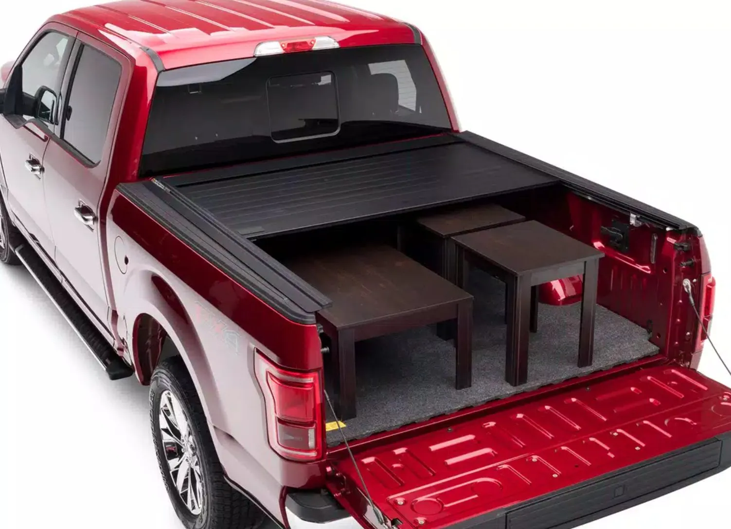 A red pickup with a retractable tonneau cover partially open, showing the cover sliding flush along the bed rails