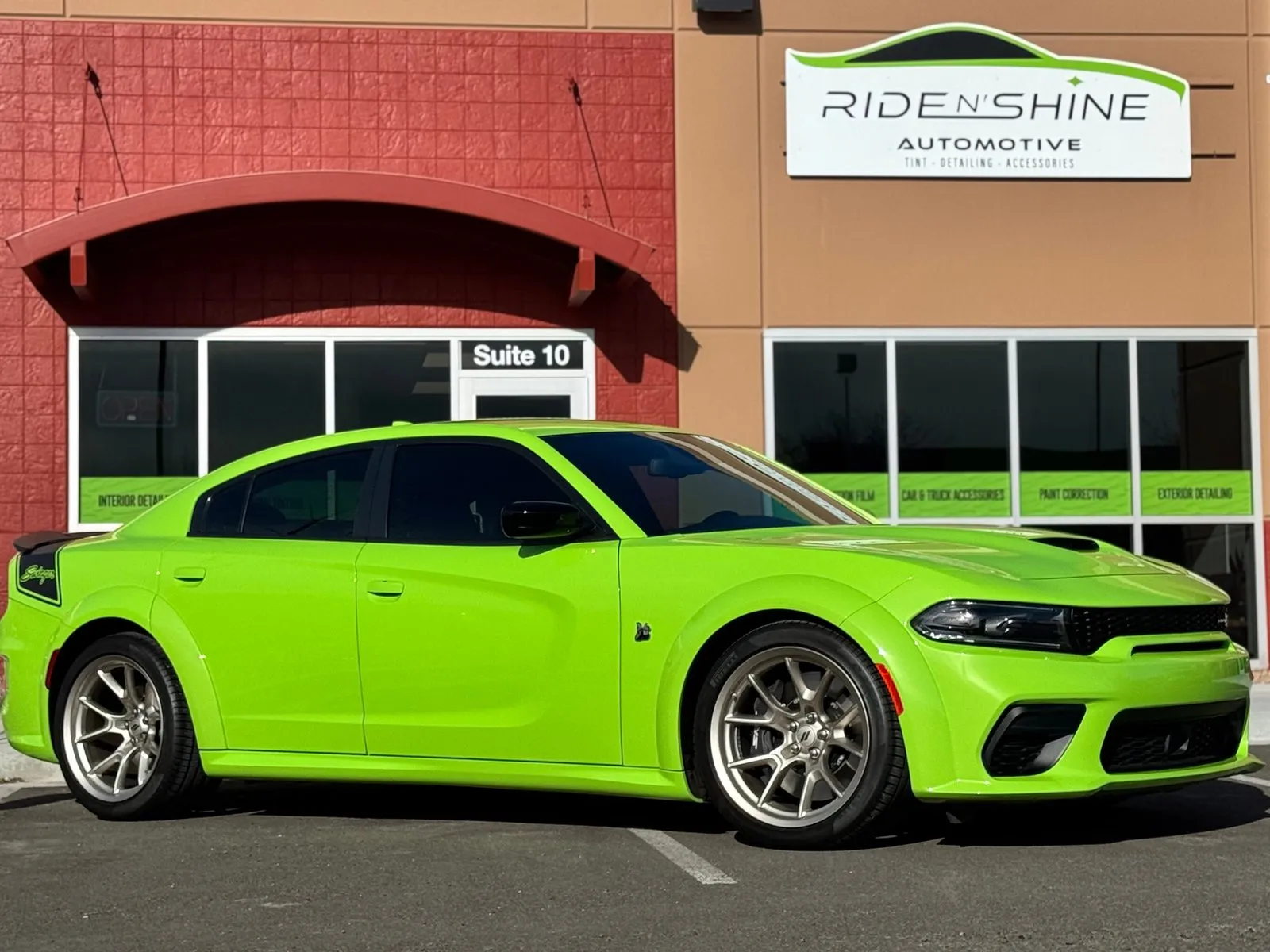 Bright green Dodge Charger parked outside the Ride N’ Shine Automotive storefront after paint protection film and ceramic coating work