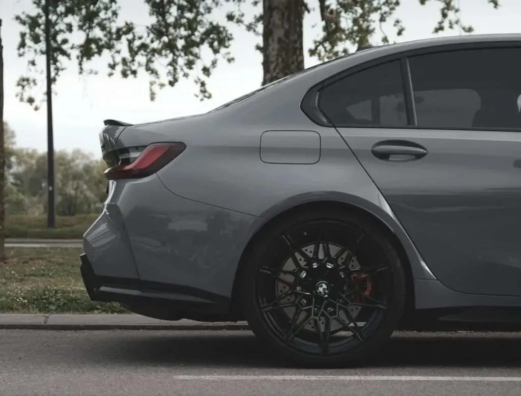 A BMW sedan parked on the street with dark ceramic tint across its rear and side windows