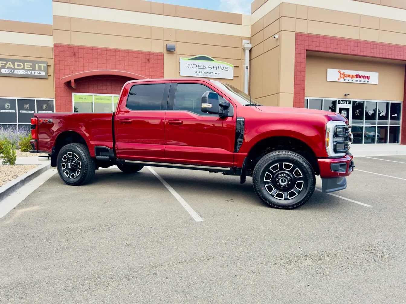 A red Ford F-250 Super Duty parked outside the Ride N' Shine storefront