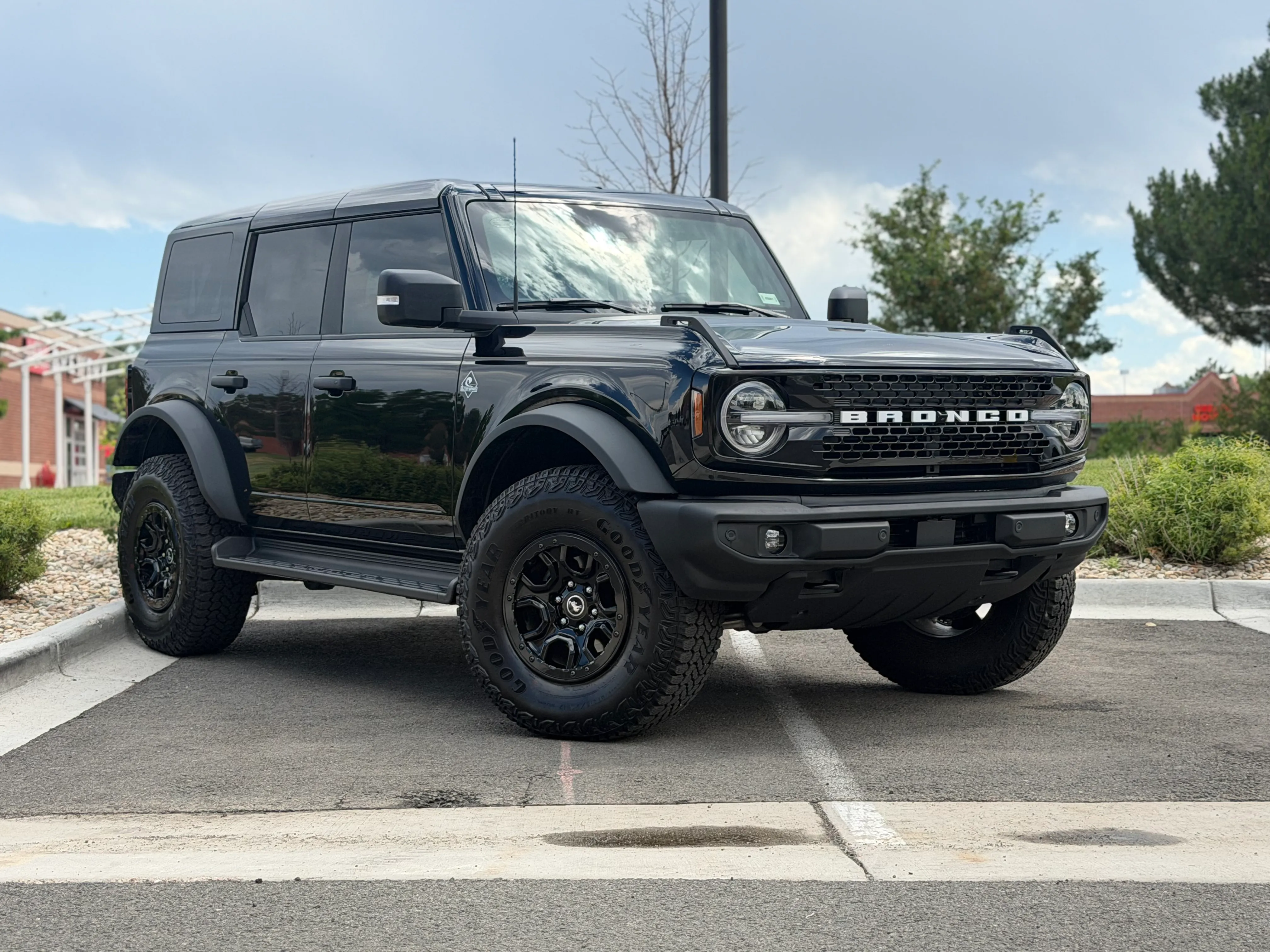 A black Ford Bronco with paint protection film parked outside the Ride N' Shine shop