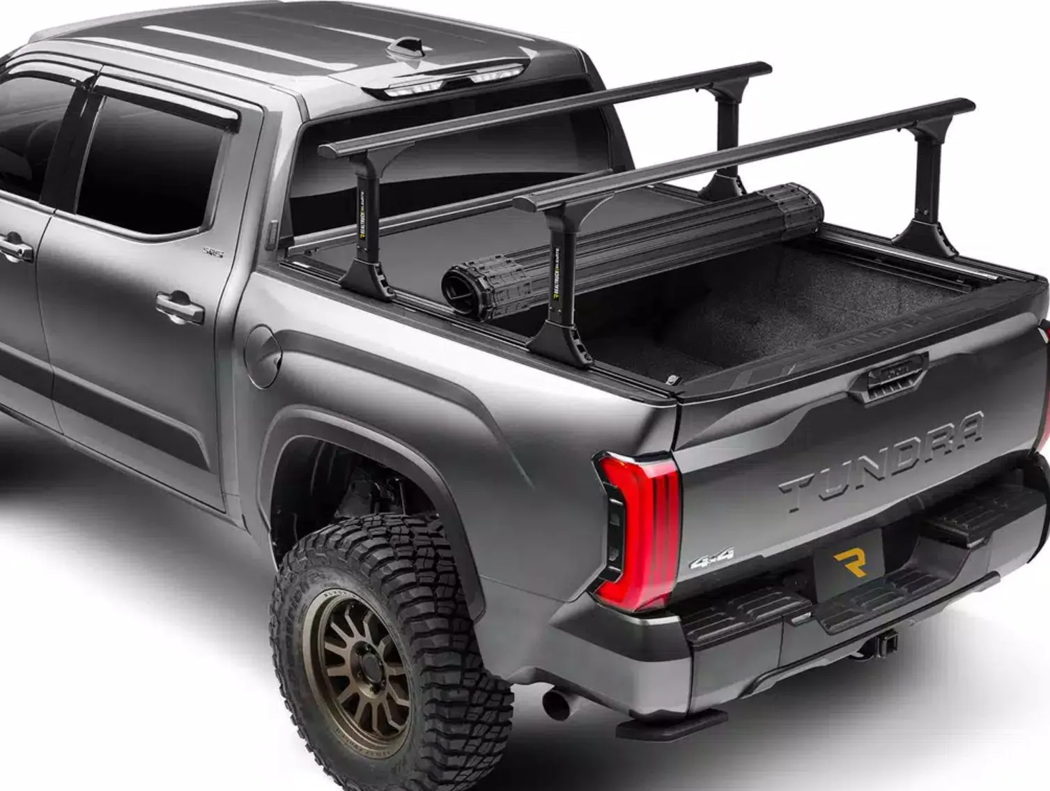 A silver Toyota Tundra fitted with the RealTruck Elevate bed rack over a rolling tonneau cover